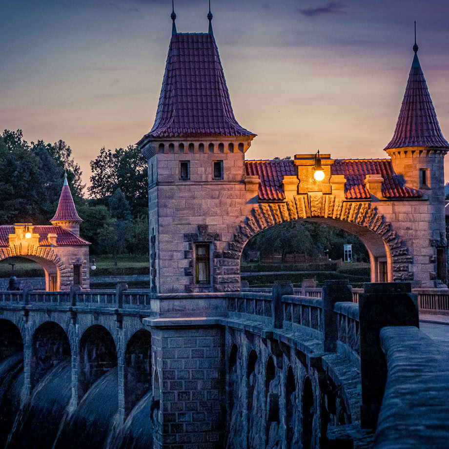 A serene A-frame cabin surrounded by lush greenery under a clear blue sky.